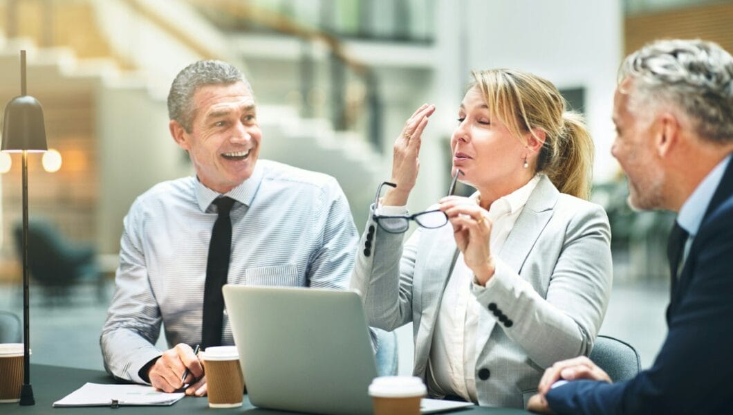 Mature businesspeople sitting and laughing together at an office table