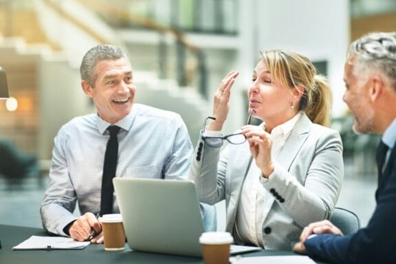 Mature businesspeople sitting and laughing together at an office table